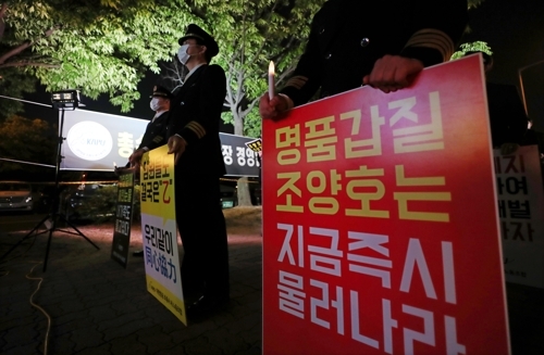 ▲ 10일 오후 서울 강서구 대한항공 본사 앞에서 열린 대한항공 총수 일가 갑질 규탄 촛불집회에서 대한항공조종사 새노조 조합원들이 손팻말을 들고 있다.  /연합