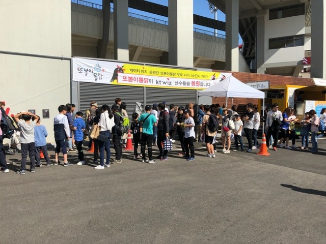 ▲ 19일 수원 케이티 위즈 파크에서 열린 또봉이통닭 무료 시식회에서 관람객들이 줄을 서 또봉이통닭 시식을 하기 위해 기다리고 있다.KT 위즈 제공