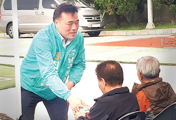 최백규 후보(바른미래당)가 전통시장에서 한 주민에게 출마인사를 하고 있다.
