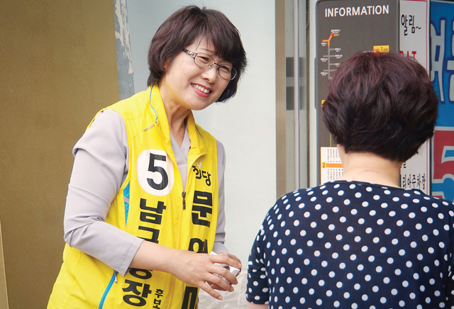문영미 후보(정의당)가 한 지역주민에게 자신의 명함을 나눠주고 있다.
