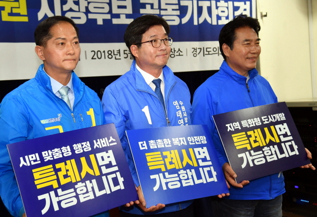 ▲ 24일 경기도의회 브리핑룸에서 열린‘100만 대도시 특례시 실현을 위한 더불어민주당 수원, 용인, 고양, 창원 시장후보 공동기자회견’에서 이재준 고양시장 후보, 염태영 수원시장 후보, 백군기 용인시장 후보가 피켓 퍼포먼스를 하고 있다. 이날 기자회견에서 염태영(수원),백군기(용인),이재준(고양) 시장 후보는 지방분권 실현을 위해 6·13 지방선거에서 “100만 대도시 특례 실현을 공동의 과제로 설정하고, 공동대응기구를 구성하기로 했다”고 밝혔다.전형민기자