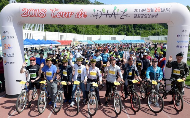 ▲ ‘2018 tour de DMZ’ 대회가 열린 26일 강원도 철원공설운동장에서 김진흥 경기도 행정2부지사, 김민재 강원도 기획조정실장, 한상협 경기관광공사 사업본부장, 신항철 경기일보 대표이사 사장, 김중석 강원도민일보 사장 등 참석내빈들과 참가자들이 완주를 다짐하고 있다. 분단 현실과 DMZ의 의미를 알리고 평화통일의 중요성을 인식시키는 계기가 된 이번 대회는 경기도와 강원도가 공동주최하고 경기관광공사, 경기일보, 강원도민일보가 공동 주관했다. 조태형기자
