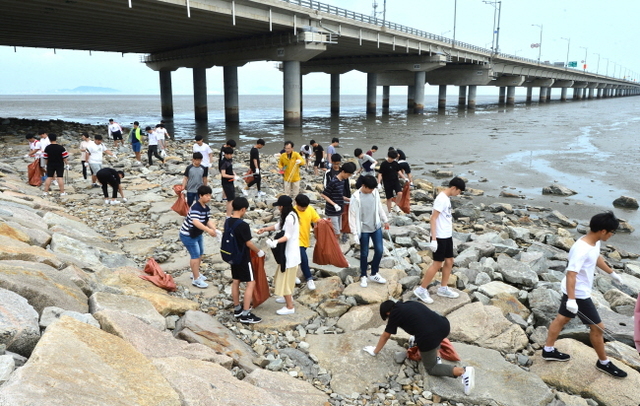 ▲ 바다의 날을 이틀 앞둔 29일 오후 인천시 중구 인천대교기념관 앞 해안에서 환경단체 회원들과 학생들이 쓰레기를 수거하고 있다.장용준기자
