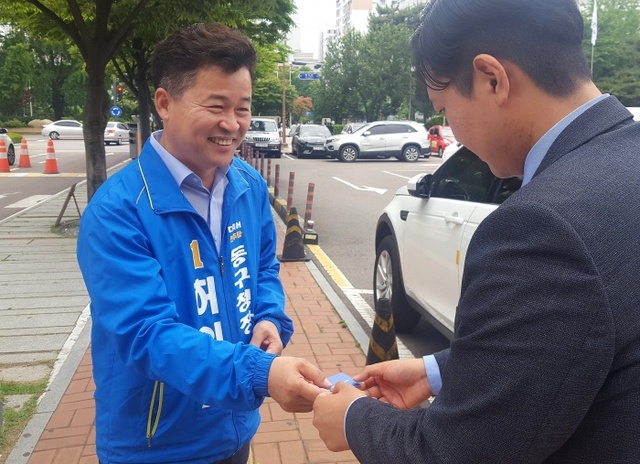 ▲ 허인환 후보(더불어민주당)가 동구 주민에게 구청장 후보 명함을 내밀며 지지를 호소하고 있다