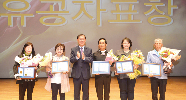 김성기 가평군수가 표창장을 수여받은 유공자들과 기념촬영을 하고 있다.