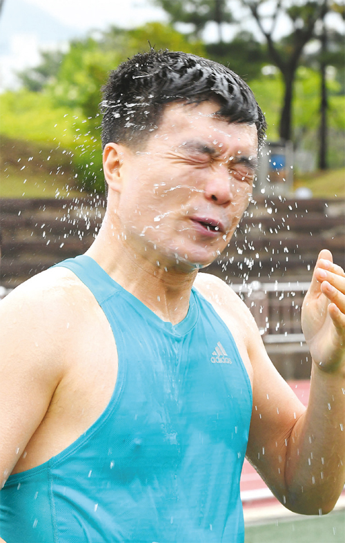 한 참가자가 완주 후 물을 뿌리며 갈증을 해소하고 있다.