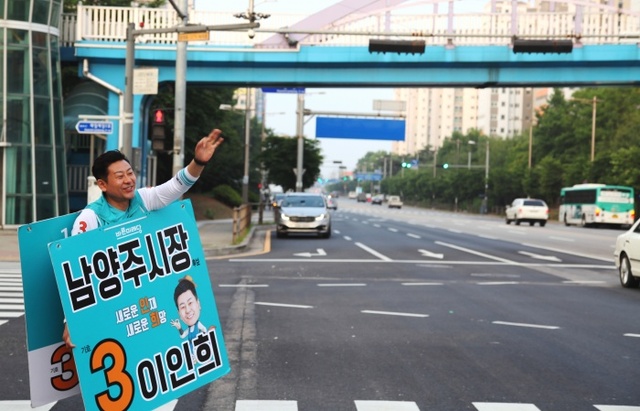 ▲ 이인희 후보가 도보 유세 중 길거리 차량에 손을 흔들고 있다