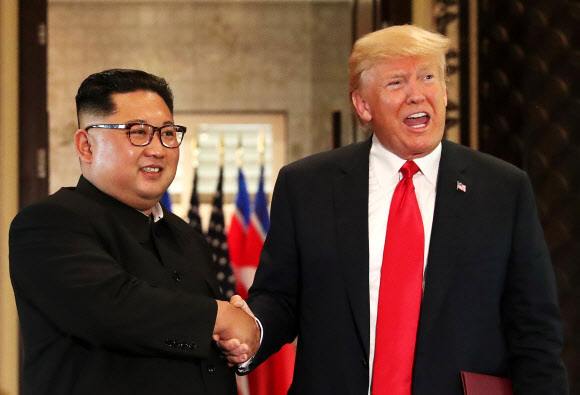 ▲ 역사적 첫 북미정상회담이 열린 12일(현지시간) 싱가포르 센토사 섬 카펠라호텔에서 미국 도널드 트럼프 대통령(오른쪽)과 북한 김정은 국무위원장이 공동합의문에 서명한 뒤 악수하고 있다. 연합뉴스