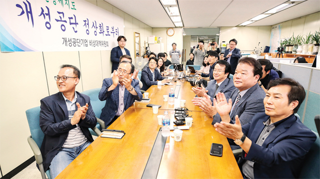 ▲ 북미 정상회담이 열린 12일 오전 서울 여의도 중소기업중앙회 내 개성공단기업협의회에서 회장단을 비롯한 관계자들이 도널드 트럼프 미국 대통령과 김정은 북한 국무위원장의 역사적인 악수장면을 지켜보며 박수를 치고 있다. 연합뉴스