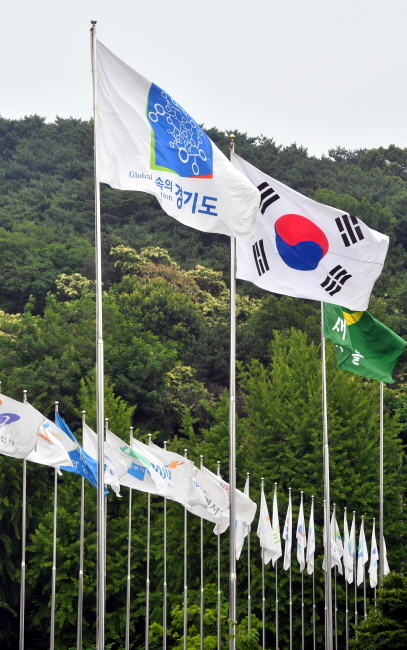 ▲ 제7회 전국동시지방선거가 마무리 되면서 경기도는 민선 7기 지자체장들을 맞이 할 준비에 돌입했다. 17일 경기도청에 게양된 경기도기와 31개 시,군 깃발들이 새주인을 기다리며 펄럭이고 있다. 김시범기자
