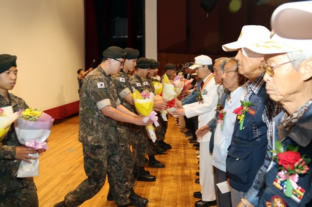 ▲ 6.25전쟁기념행사에서후배장병들이참전용사들에게꽃다발을전달하고있다.