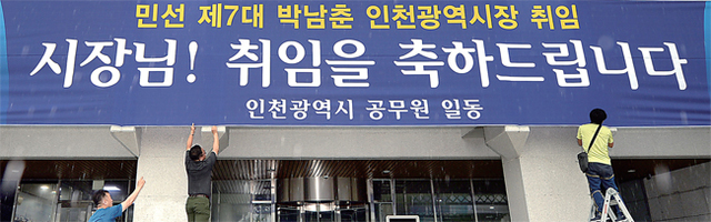 ▲ 1일 오전 인천시청 본관 현관 입구에서 시 총무과 청사관리팀 직원들이 민선 7대 박남춘 인천시장 취임을 축하하는 현수막을 본관 입구에 설치하고 있다. 박 시장은 2일 취임식 대신 현충탑 참배와 재난상황실을 방문한 뒤 본격적인 시정 업무를 챙긴다. 송길호기자