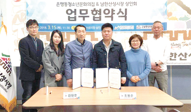 남한산성시장 상인회와 은행동청소년문화의집이 업무협약식 기념 촬영을 하고 있다.