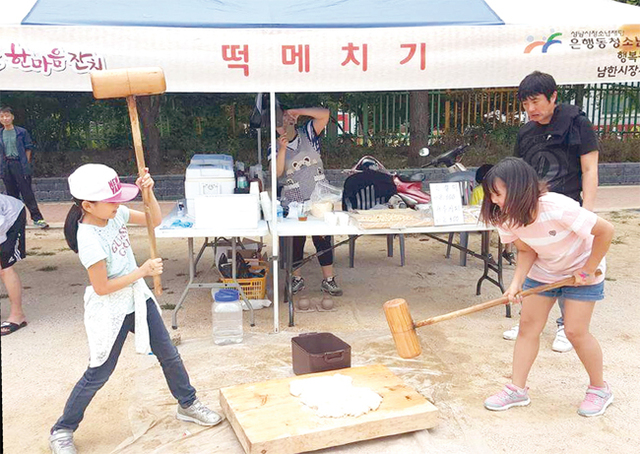 남한산성시장에서 열린 은행골 한마음잔치에서 학생들이 떡메치기를 하고 있다.