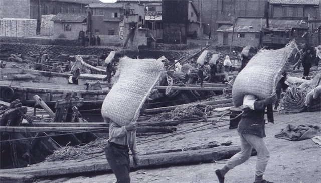 1960년대 초반 인천항 대한싸이로 위치에서 노동자들이 포대(가마니) 가데기작업을 하고 있다.