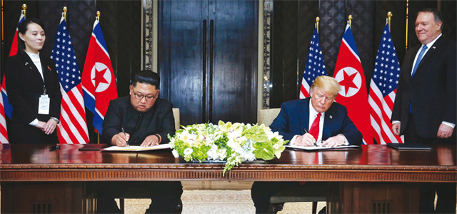 역사적 첫 북미정상회담이 열린 6월12일 오후 싱가포르 센토사 섬 카펠라호텔에서 북한 김정은 국무위원장과 미국 도널드 트럼프 대통령이 공동합의문에 서명하고 있다. 왼쪽은 김여정 당 제1부부장, 오른쪽은 마이크 폼페이오 국무장관.