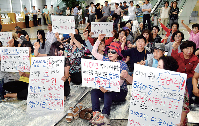 ▲ 성남시청을 항의 방문한 성남시 중원구 금광래미안아파트 주민들이 9일 시청로비에서 시민들이 수십 년 동안 이용하고 있는 금광동 2528-2번지 시유지에 개설된 도로 원상 복구와 매각 철회를 요구하고 있다. 전형민기자