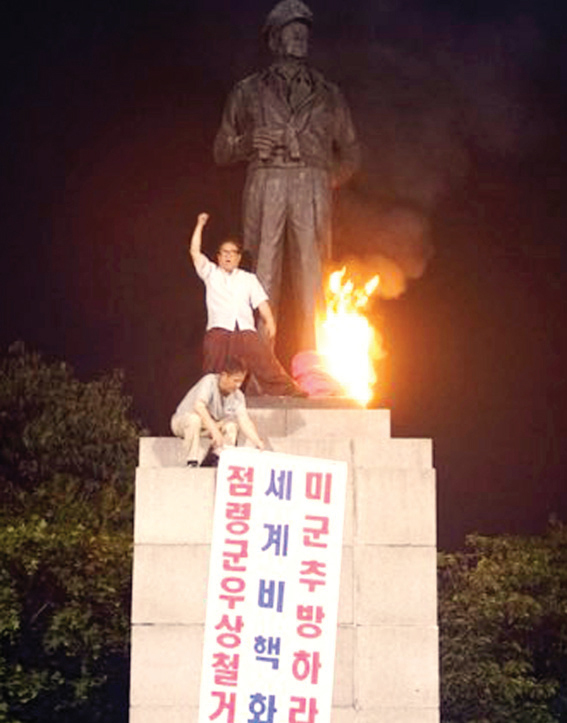 ▲ 진보단체 회원들이 27일 새벽 인천시 중구 자유공원 내에 있는 맥아더 장군 동상에 불을 지른 뒤 구호를 외치고 있다. 연합뉴스