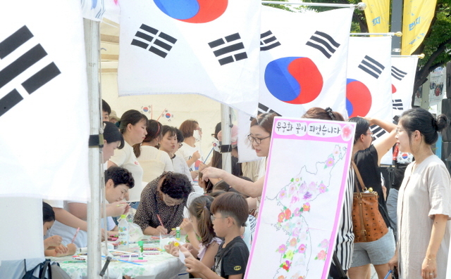 ▲ 5일 인천국학운동시민연합 주최로 인천문화예술회관 광장에서 열린 제73회 광복절 기념 부대행사를 찾은 어린이들이 엄마와 함께 무궁화 꽃 그리기 체험부스에서 무궁화 꽃을 그리고 있다. 송길호기자