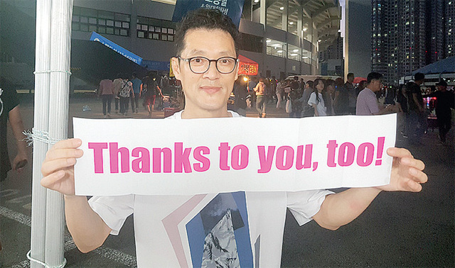 조용필 팬클럽 ‘위대한 탄생’ 윤석수 회장이 공연장 앞에서 ‘thanks to you’가 적힌 응원글을 들고 기념사진을 촬영하고 있다. 