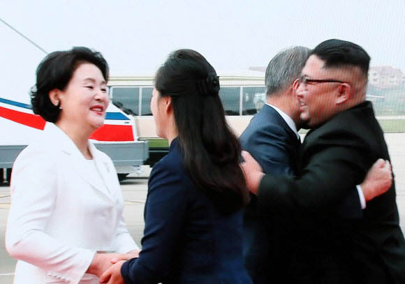 ▲ ''2018남북정상회담평양''의 첫날인 18일 평양 순안공항에 도착한 문재인 대통령이 마중 나온 김정은 북한 국무위원장과 포옹하는 장면이 이날 서울 중구 DDP 메인프레스센터에 중계되고 있다. 평양공동취재단