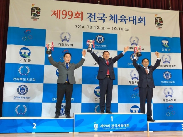 ▲ 16일 전북 고창군립체육관에서 열린 제99회 전국체육대회 유도 시상식에서 20연패를 달성한 경기도의 서정복 유도회장(가운데)이 시상대 가장 높은 곳에서 우승트로피를 들어보이고 있다.