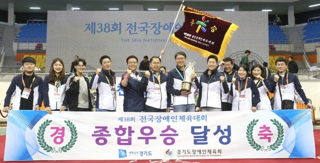 ▲ 29일 익산실내체육관에서 열린 제38회 전국장애인체육대회 폐회식에서 2년 만에 종합우승을 차지한 경기도선수단이 우승기와 우승배를 들고 기념촬영을 하고 있다.경기도장애인체육회 제공