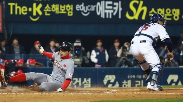 ▲ 5일 서울 잠실야구장에서 열린 2018 프로야구 한국시리즈 SK 와이번스와 두산 베어스의 2차전 경기. 5회초 1사 주자 3루 SK 김강민의 희생플라이 때 3루 주자 박승욱이 홈에 들어오고 있다.연합뉴스
