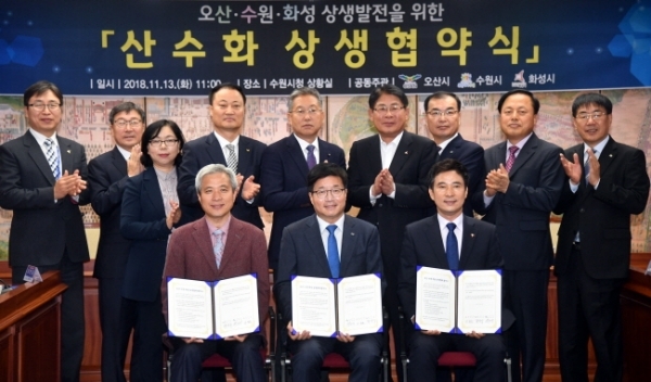 13일 수원시청 상황실에서 열린 오산ㆍ수원ㆍ화성 공동번영을 위한 ‘산수화 상생협약식’에서 (왼쪽부터) 곽상욱 오산시장, 염태영 수원시장, 서철모 화성시장이 협약서에 서명 후 참석자들과 기념촬영을 하고 있다.전형민기자