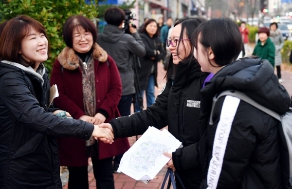 2019학년도 대학수학능력시험일인 15일 오전 수원 광교고에 마련된 경기도교육청 제30지구 제1시험장에서 수험생들이 부모, 선생님, 후배 등의 응원을 받으며 시험장에 들어가고 있다. 김시범기자