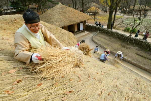 18일 용인 한국민속촌에서 관계자들이 초가지붕에 올릴 용마름과 이엉 잇기 작업을 하며 월동준비를 하고 있다. 조태형기자