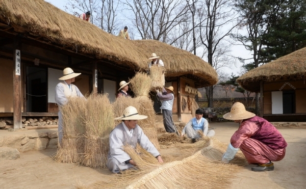 18일 용인 한국민속촌에서 관계자들이 초가지붕에 올릴 용마름과 이엉 잇기 작업을 하며 월동준비를 하고 있다. 조태형기자