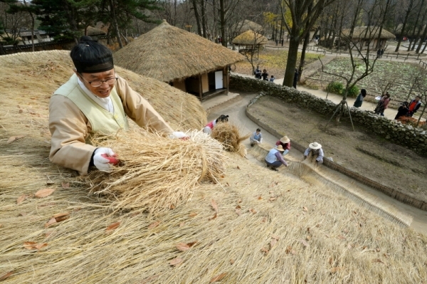 18일 용인 한국민속촌에서 관계자들이 초가지붕에 올릴 용마름과 이엉 잇기 작업을 하며 월동준비를 하고 있다. 조태형기자