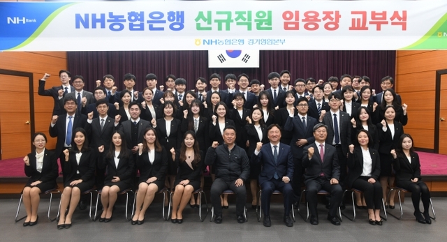 NH농협은행 경기영업본부가 19일 대회의실에서 2018년 하반기 6급 신규직원 임용장 교부식을 개최한 가운데 신규직원들이 권준학 본부장과 함께 파이팅을 외치고 있다. 이날 임용된 50명의 신규직원은 7주간의 교육과정을 거친 뒤 내년 1월 초 경기 관내 영업점에 배치될 예정이다. NH농협은행 경기영업본부 제공