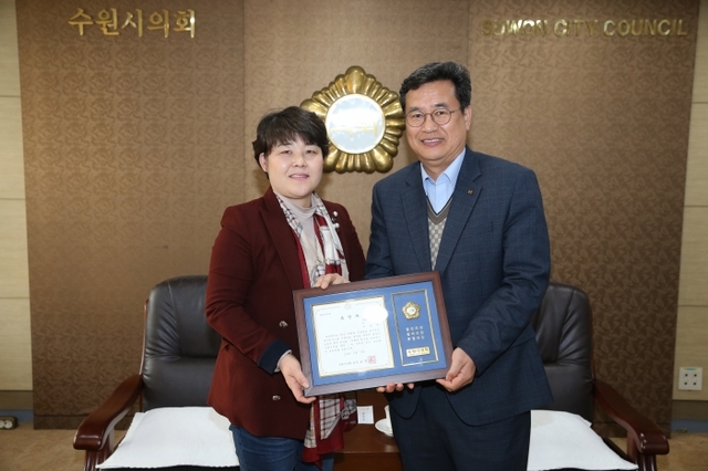 19일 수원시의회에서 열린 ‘지역사회발전유공 수원시의회 의장상 표창 수여식’에서 조명자 수원시의회 의장이 임종택 전 kt wiz 단장에게 표창패를 전달한 뒤 기념촬영을 하고 있다. 수원시의회 제공