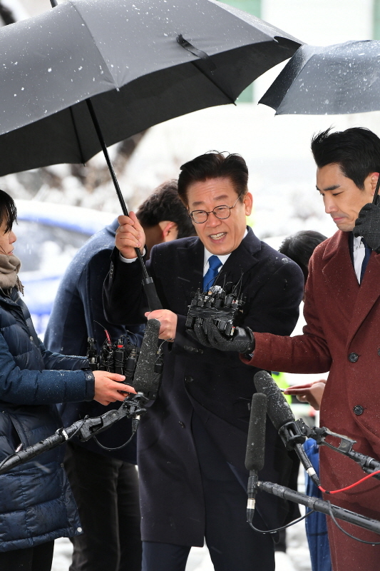 이재명 경기도지사가 24일 수원지방검찰청 성남지청에서 조사를 받기 위해 출석하던 중 바람이 불자 우산을 잡고 있다. 검찰 조사는 경찰이 기소 의견으로 송치한 친형 강제입원, 검사 사칭, 성남시 분당구 대장동 개발 관련 허위사실 공표 등 3건과 배우 김부선 씨와 관련된 여배우 스캔들에 대해서 진행될 예정이다. 조태형기자