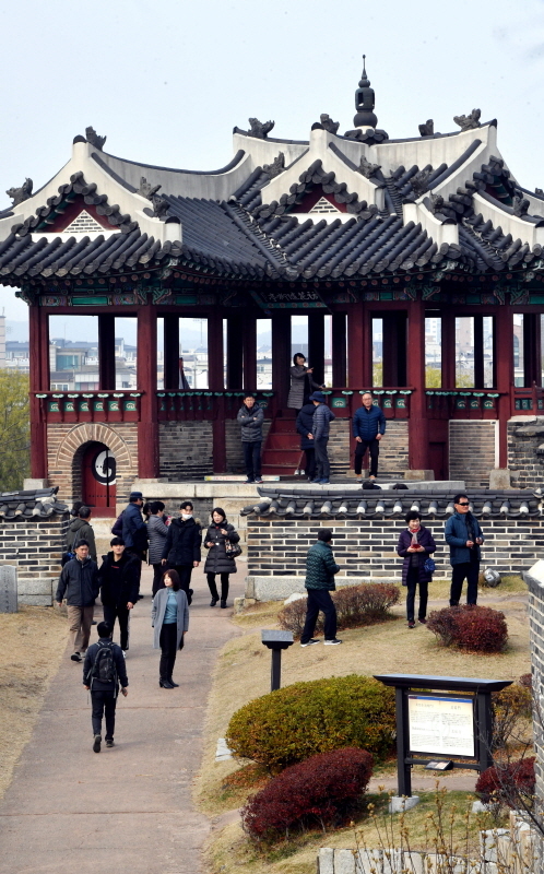 추위가 풀린 뒤 초미세먼지가 ‘나쁨’ 수준을 보인 25일 휴일을 맞아 수원화성을 찾은 관광객들이 화홍문 방화수류정을 둘러보고 있다.전형민기자