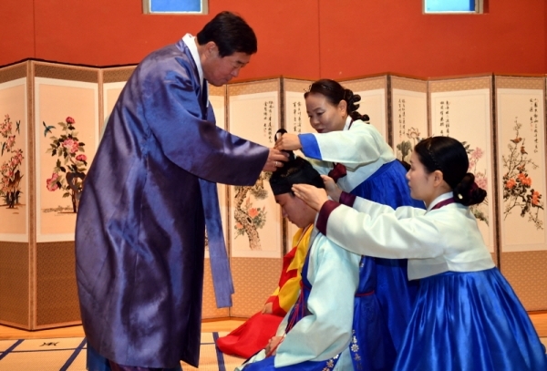 28일 안산시 상록구 성포동 안산시청소년수련관에서 열린 안산시행복예절관 ‘2018년 찾아가는 전통 성년례’에서 윤화섭 안산시장이 성포고등학교 학생들에게 남자에게 어른의 복색을 입히고 관(冠ㆍ모자)를 씌우는 의식인 전통 관례식을 거행하고 있다.전형민기자  전형민기자