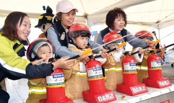 김포시 서우문화체육광장에서 열린 2018 김포 시민안전 마을공동체 사회적경제 페스티벌에서 어린이들이 소화기 사용법을 배우고 있다.