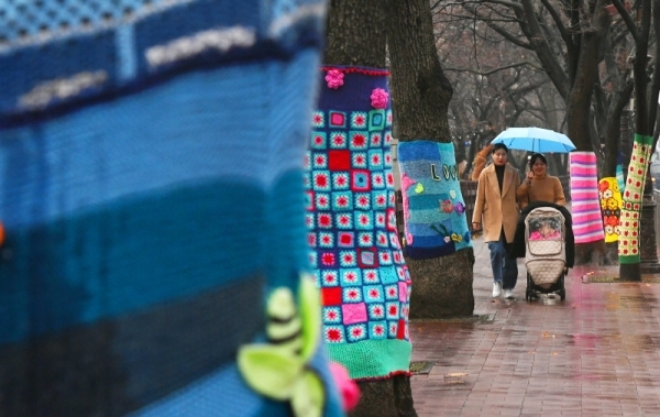 전국이 대체로 흐리고 비가 내린 3일 안양예술공원에서 시민들이 우산을 쓴 채 알록달록 털실 옷을 입은 가로수 길을 걷고 있다. 기상청은 