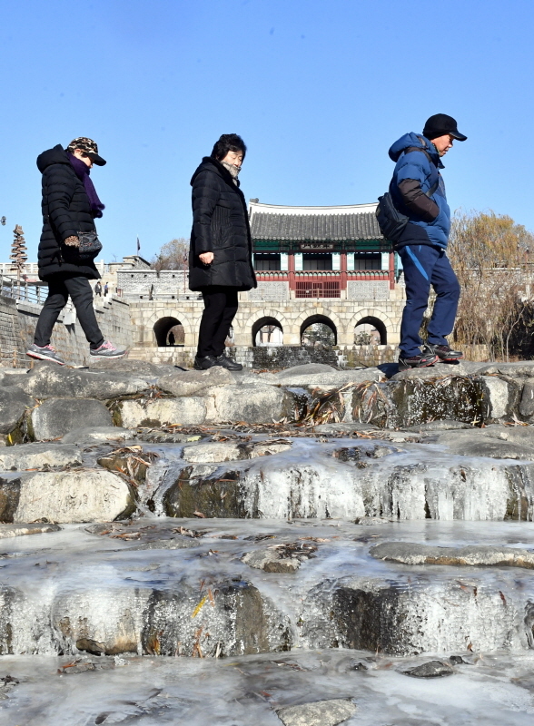 최저기온이 수원 영하 11.도 기록하는 등 올 겨울들어 가장 추운날씨를 보인 9일 꽁꽁 얼어붙은 수원화성 화홍문 인근 수원천에서 시민들이 산책을 하고 있다.  기상청은 이번 강추위가 당분간 계속될 것이라고 예보했다.전형민기자