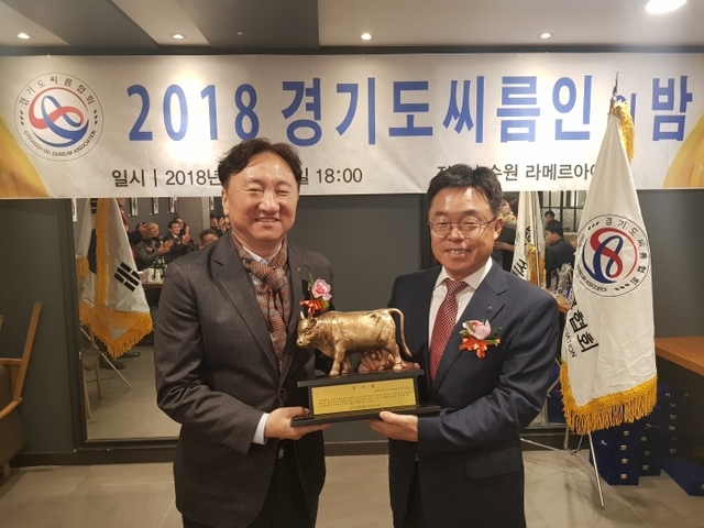 ▲ 2018 경기도씨름인의밤 행사에서 권준학 경기도씨름협회장(왼쪽)이 직전 남창현 회장에게 감사트로피를 전달하고 있다