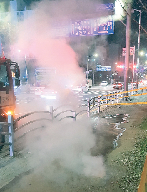 지난 12일 오후 8시35분 안산시 단원구의 한 아파트 단지 인근에서 온수관이 파열돼 뜨거운 물과 연기가 나오고 있다. 경기도소방재난본부제공