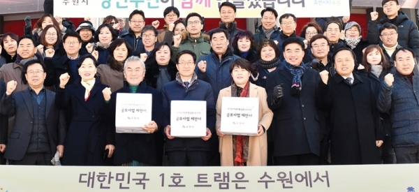수원시와 성남시가 한국철도기술연구원에 ‘무가선 저상 트램 실증노선 선정 공모 사업’ 제안서를 각각 제출했다. 사진은 지난 14일 제안서 접수 전 무가선 저상트램 제안노선의 종점인 kt 위즈파크 앞에서 백운석 수원시 제2부시장, 조명자 수원시의회 의장 등 수원시 관계자들이 기념촬영을 하고 있는 모습. 수원시 제공