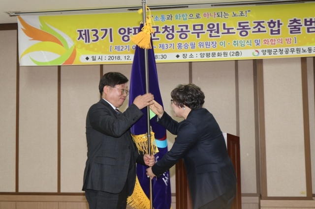홍승필 신임 노조위원장(왼쪽)과 이윤실 전 노조위원장이 조합기를 인수인계하고 있다.