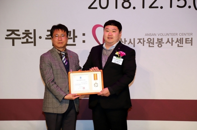 ▲ 자원봉사 활성화 기업으로 선정된 LSAT의 윤성식 대리가 경기도 지사 유공 표창을 받고있다.