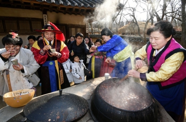 절기상 동지를 맞아 세시풍속 체험행사 ‘동지야(夜)’가 열린 23일 용인 한국민속촌에서 시민들이 가마솥에서 직접 끓여낸 팥죽을 맛보고 있다. 조태형기자