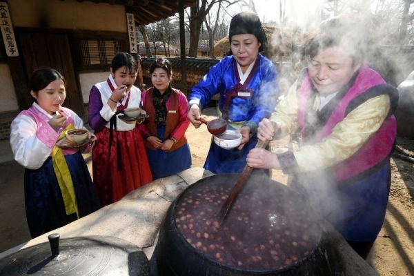 절기상 동지를 맞아 세시풍속 체험행사 ‘동지야(夜)’가 열린 23일 용인 한국민속촌에서 시민들이 가마솥에서 직접 끓여낸 팥죽을 맛보고 있다. 조태형기자
