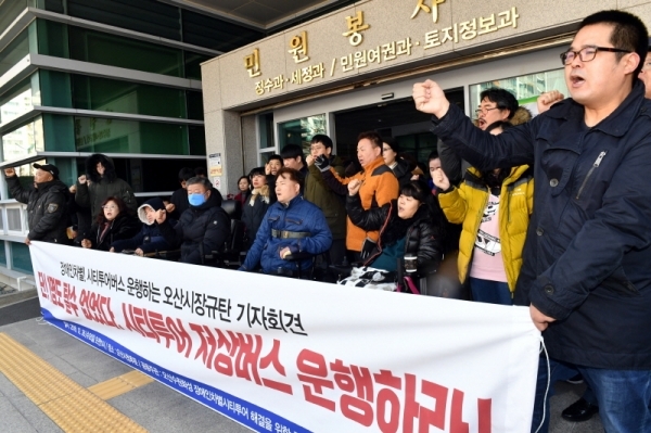 26일 오산시청 후문 앞에서 열린 ‘장애인차별! 시티투어버스 운행하는 오산시장규탄 기자회견’에서 오산수원화성 장애인차별 시티투어 해결을 위한 공동대책위원회 등 참석자들이 “시티투어 저상버스 운행”을 요구하고 있다.전형민기자