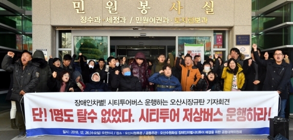 26일 오산시청 후문 앞에서 열린 ‘장애인차별! 시티투어버스 운행하는 오산시장규탄 기자회견’에서 오산수원화성 장애인차별 시티투어 해결을 위한 공동대책위원회 등 참석자들이 “시티투어 저상버스 운행”을 요구하고 있다.전형민기자